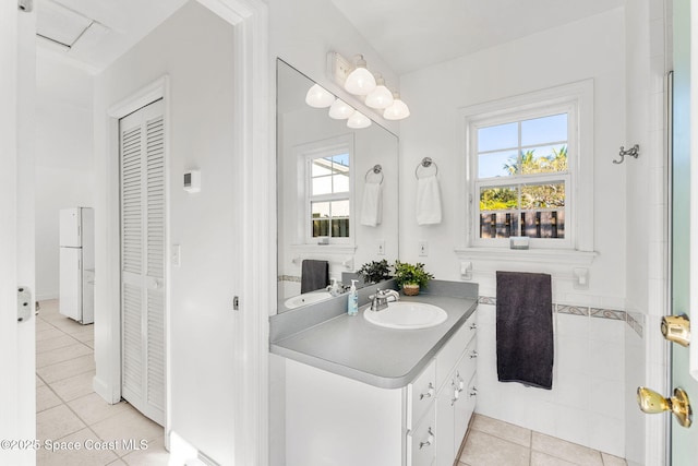 bathroom with a wealth of natural light, a closet, vanity, and tile patterned floors