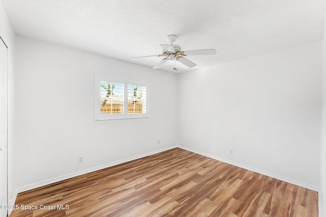 unfurnished room featuring a textured ceiling, a ceiling fan, light wood-style flooring, and baseboards