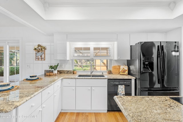 kitchen featuring black appliances, light wood-style floors, a peninsula, and white cabinets