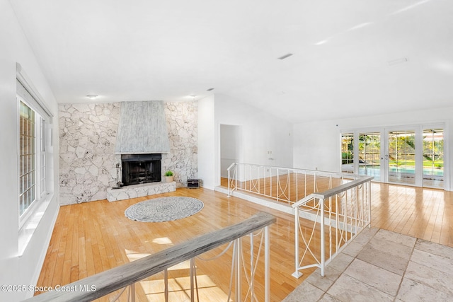 interior space featuring lofted ceiling, french doors, an upstairs landing, and hardwood / wood-style flooring