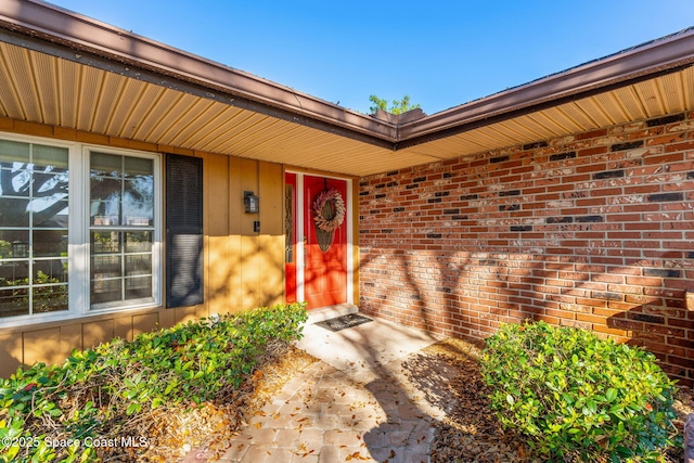 doorway to property featuring brick siding