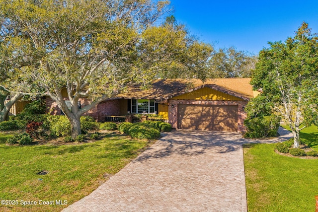 single story home featuring a garage, a front yard, decorative driveway, and brick siding