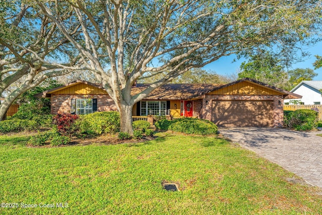 single story home with driveway, a garage, fence, a front lawn, and brick siding