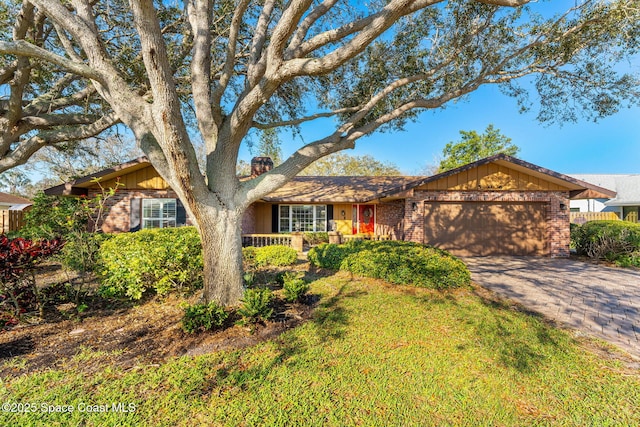 single story home with decorative driveway, brick siding, and an attached garage