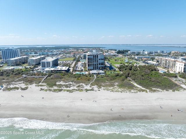 birds eye view of property with a city view, a water view, and a beach view