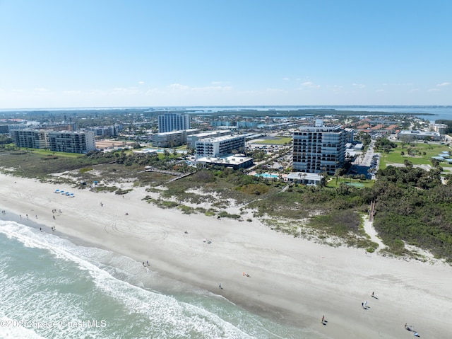 drone / aerial view featuring a view of the beach, a city view, and a water view