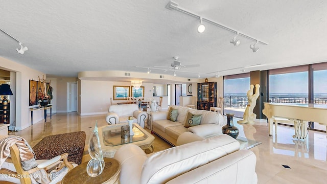 living area with a ceiling fan, visible vents, and a textured ceiling