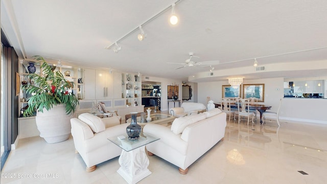 living area with rail lighting, light tile patterned floors, visible vents, and ceiling fan with notable chandelier