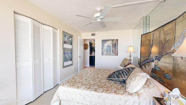 bedroom with ceiling fan, a textured ceiling, visible vents, and a closet