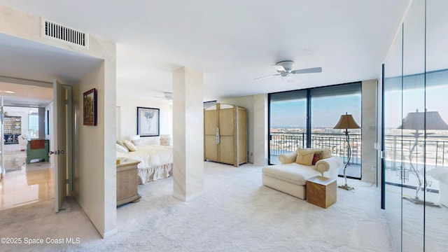 bedroom featuring a wall of windows, access to outside, visible vents, and light colored carpet