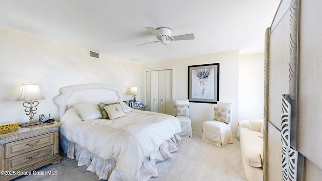 bedroom featuring a ceiling fan, visible vents, a closet, and light colored carpet