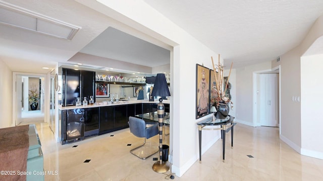 interior space featuring light countertops, dark cabinetry, visible vents, and baseboards