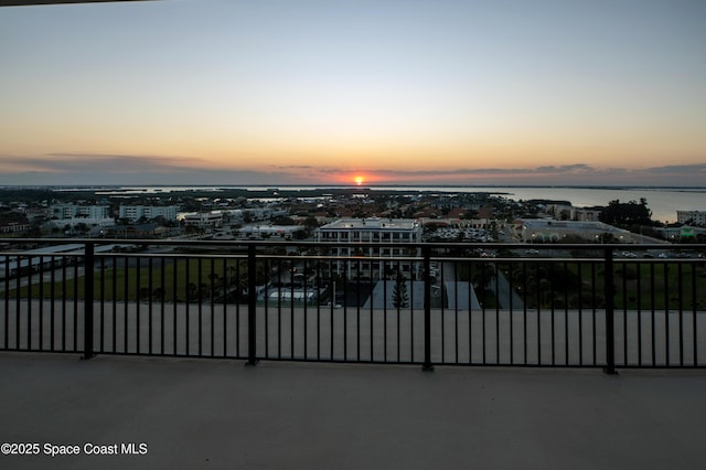 gate at dusk featuring a view of city and a water view