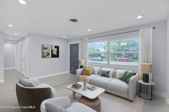 tiled living room featuring baseboards, a textured ceiling, visible vents, and recessed lighting