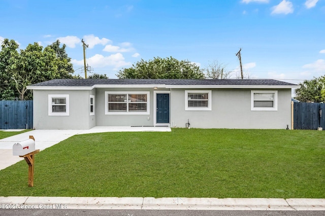 ranch-style house with a front yard, fence, and stucco siding