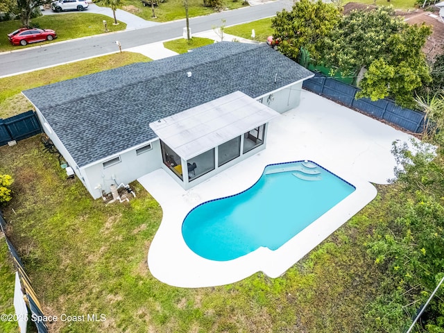 view of pool with fence private yard, a sunroom, and a yard