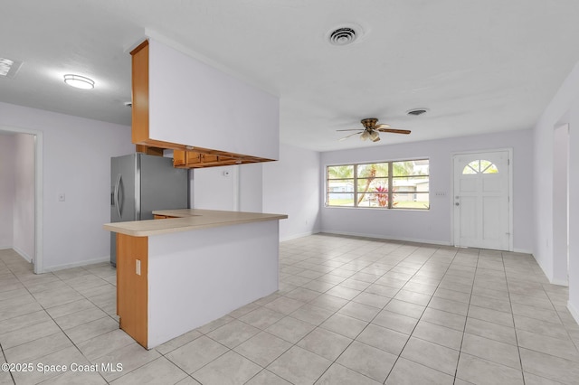 kitchen with ceiling fan, light tile patterned floors, visible vents, baseboards, and light countertops