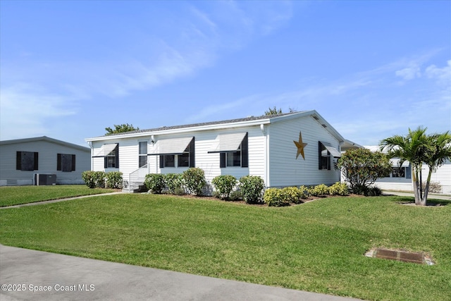 manufactured / mobile home with central air condition unit and a front yard