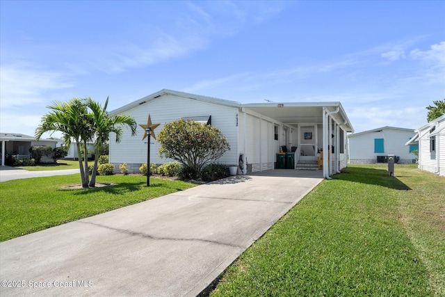 manufactured / mobile home featuring driveway, an attached carport, and a front yard