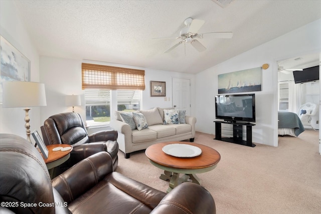 carpeted living room featuring a ceiling fan, vaulted ceiling, and a textured ceiling