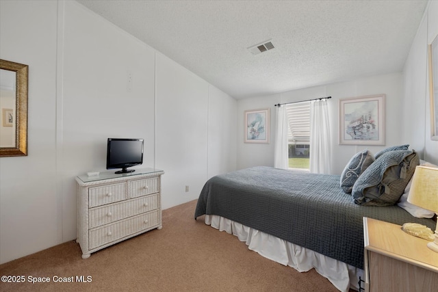 carpeted bedroom with visible vents and a textured ceiling