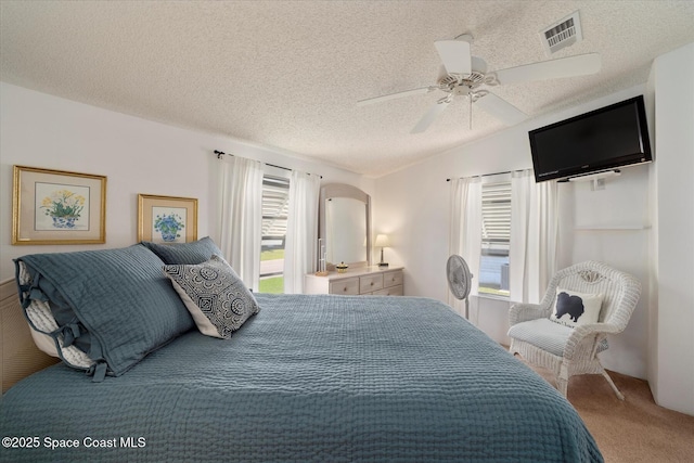 carpeted bedroom with ceiling fan, a textured ceiling, arched walkways, visible vents, and vaulted ceiling