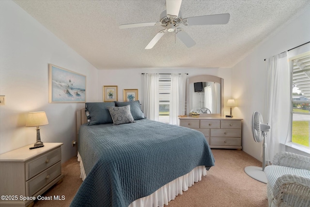 bedroom with light carpet, ceiling fan, vaulted ceiling, and a textured ceiling