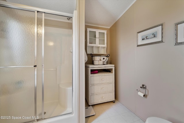 bathroom with toilet, a stall shower, and a textured ceiling