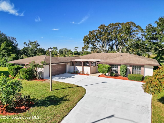 ranch-style home featuring an attached garage, driveway, and a front yard