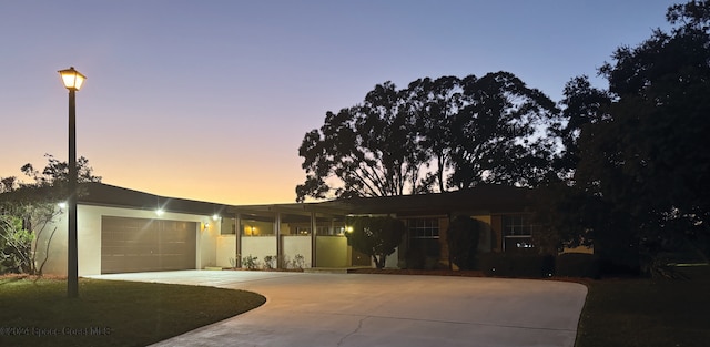 ranch-style house featuring a garage, concrete driveway, and stucco siding