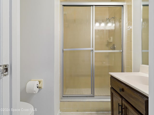 bathroom featuring a shower stall, toilet, and vanity