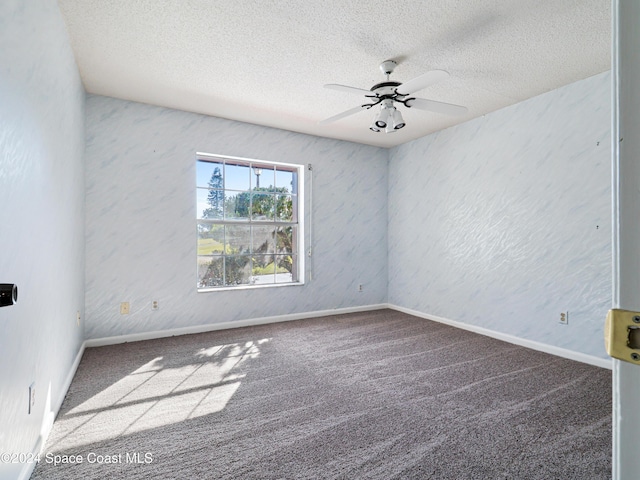 carpeted spare room with ceiling fan, baseboards, and a textured ceiling