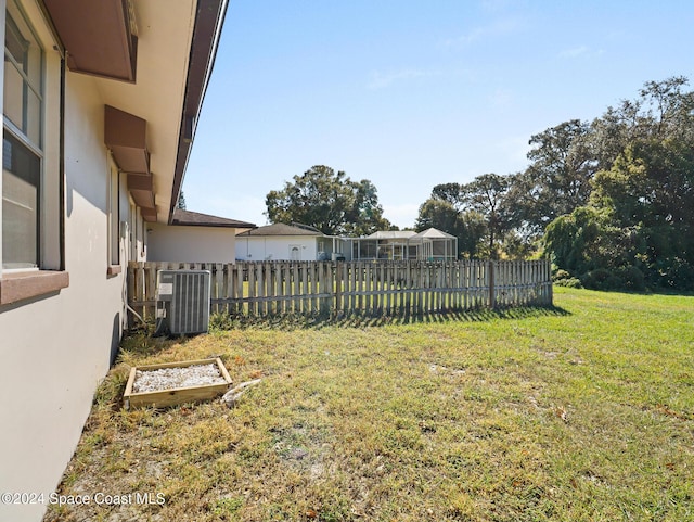 view of yard with fence and central AC unit