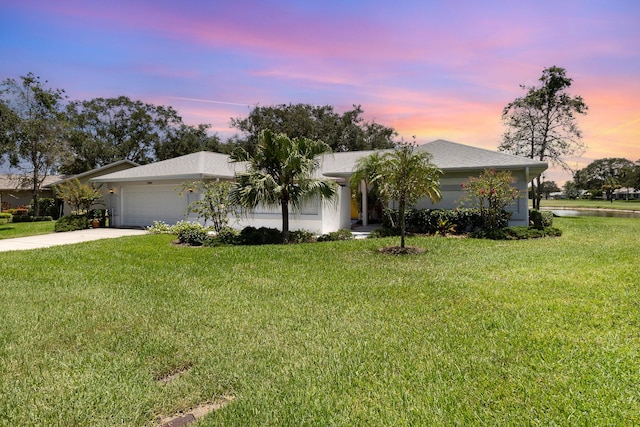 single story home featuring a front yard, driveway, and an attached garage