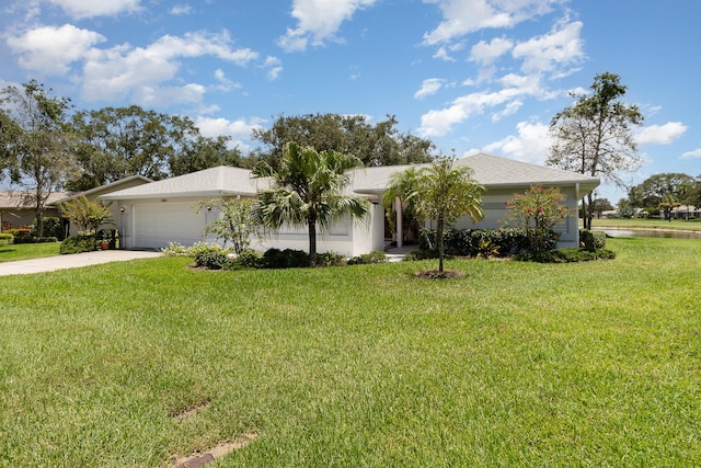 ranch-style home featuring a front yard, concrete driveway, an attached garage, and stucco siding