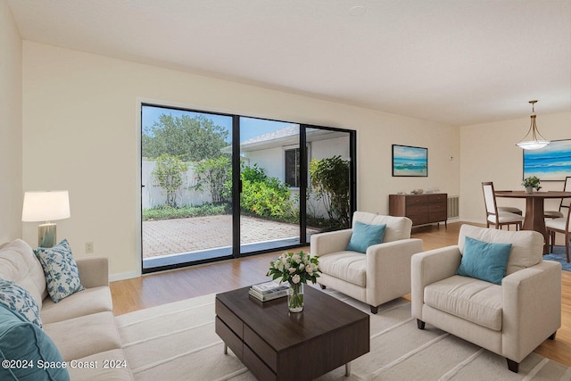 living area with light wood-type flooring and baseboards