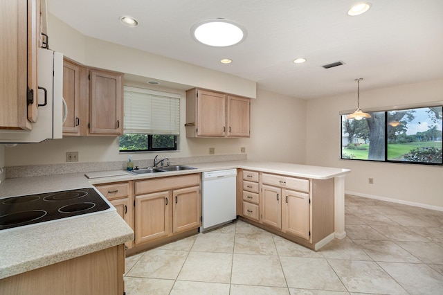 kitchen with light brown cabinets, a peninsula, a sink, visible vents, and dishwasher