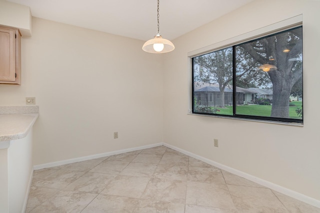 unfurnished dining area featuring baseboards