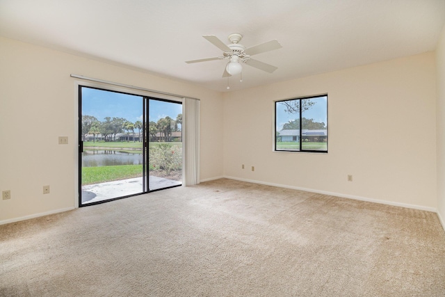 unfurnished room with ceiling fan, baseboards, a wealth of natural light, and light colored carpet