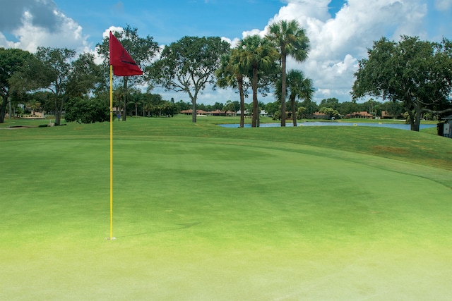 view of home's community with view of golf course and a yard