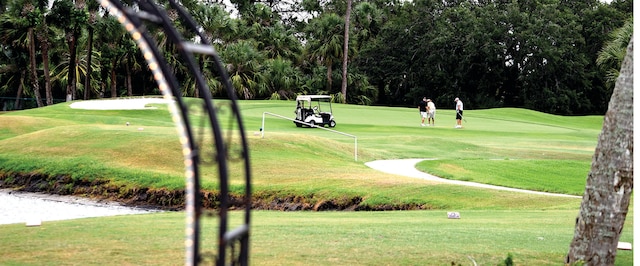 view of property's community featuring golf course view and a yard