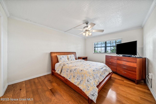 bedroom featuring a textured ceiling, ceiling fan, baseboards, light wood-type flooring, and crown molding