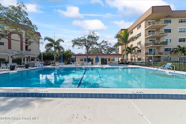 community pool featuring a patio area and fence