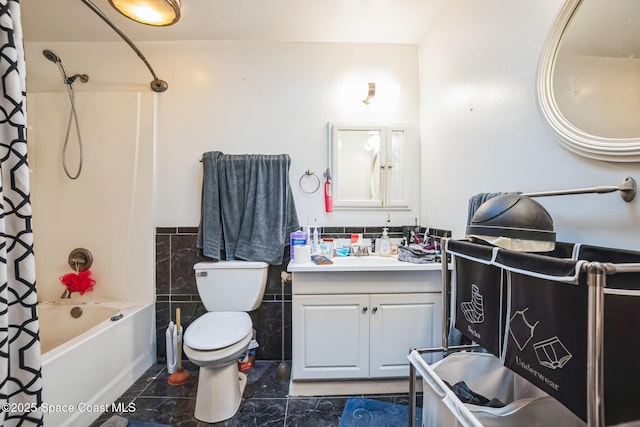 bathroom featuring a wainscoted wall, tile walls, toilet, shower / bath combo with shower curtain, and vanity