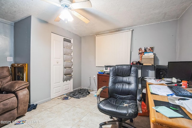 office space with a textured ceiling, baseboards, a ceiling fan, and light tile patterned flooring