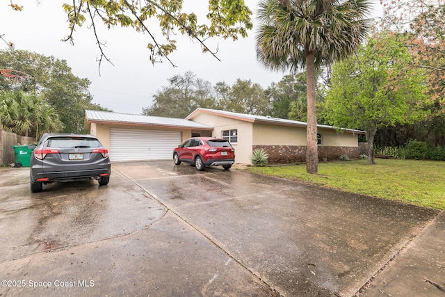 view of front of house featuring a front yard, concrete driveway, and stucco siding