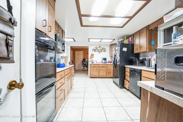 kitchen with light countertops, black appliances, and light tile patterned floors