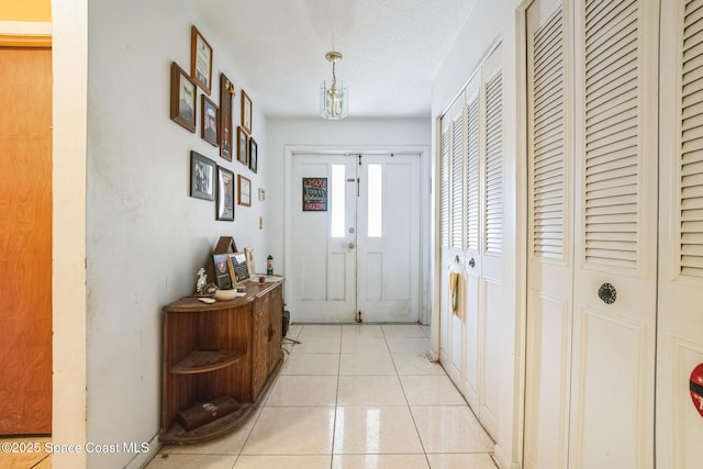 entrance foyer with french doors, a textured ceiling, and light tile patterned floors