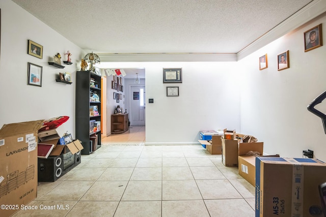 interior space with light tile patterned floors, a textured ceiling, and crown molding