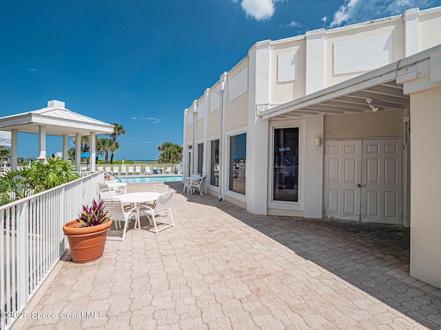 view of patio / terrace featuring a community pool and a gazebo